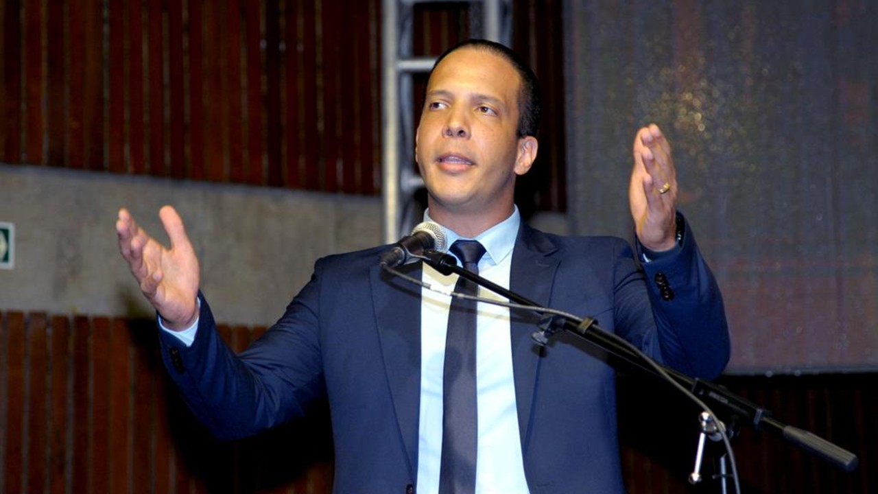 Murilo Félix discursando de terno azul, gravata azul e camisa branca